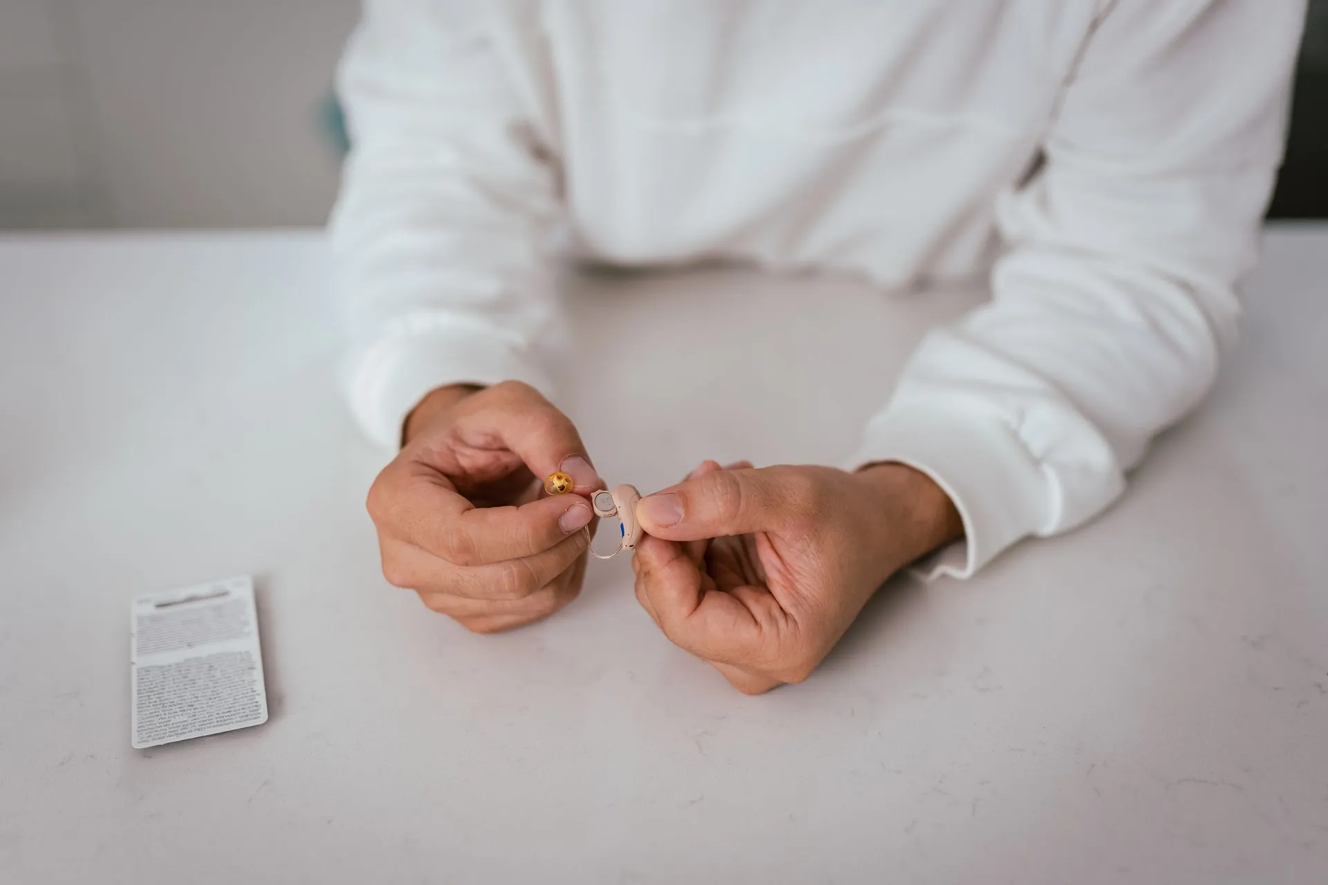 Audiologist holding a hearing aid and its battery